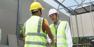 中等拍摄的亚洲同事，工人，人们在建筑现场工作。男工头工程师在施工方检查工作进度，领导在讲解项目情况。