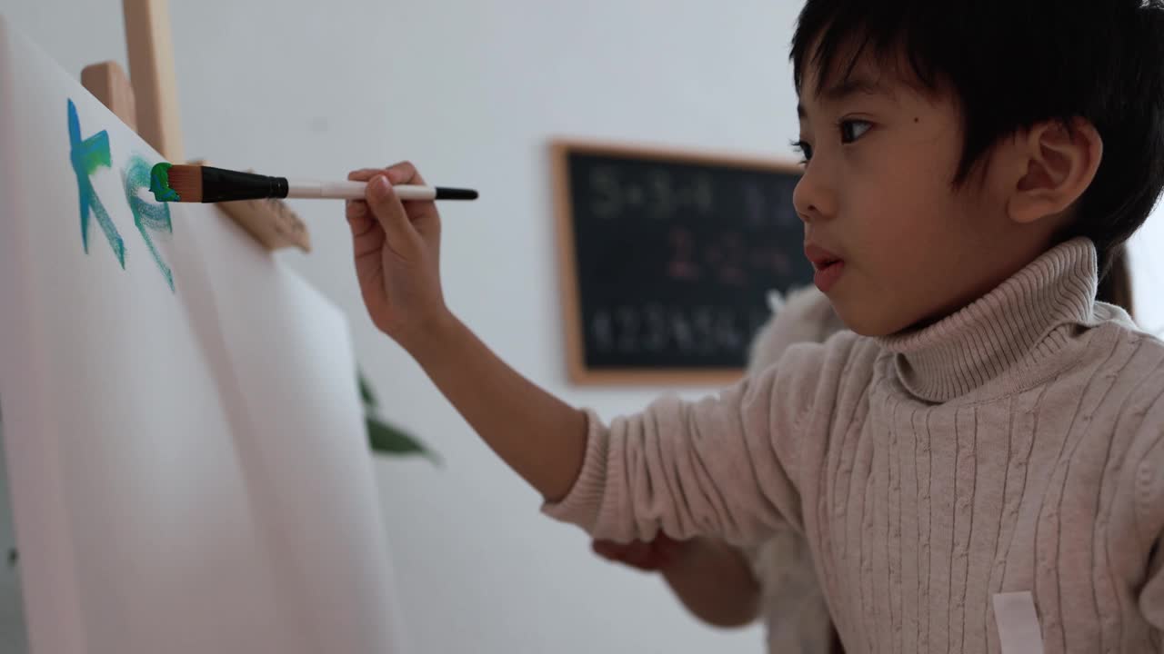 亚洲小孩用彩色画笔在画布上作画-母亲和孩子在家里一起创作艺术作品