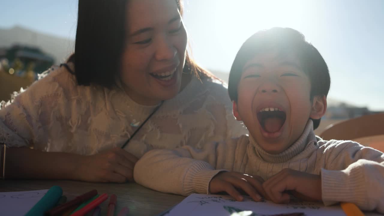 亚洲母亲和儿子一起在户外露台上玩-小孩子做滑稽的脸