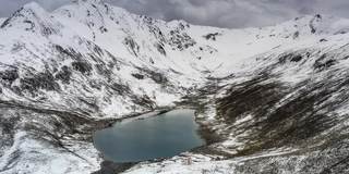 在一个阴天，蓝色的湖躺在雪山的怀抱