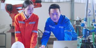 年轻的亚洲工业机器人工程师工作测试和程序机器人手臂在一个研究实验室与现代设备一起。人与科技或创新的观念。