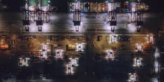 繁忙的工业港口，集装箱船在夜间鸟瞰图