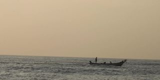 早上，人们在海洋中乘木筏钓鱼。海浪翻滚翻滚，波浪起伏，美丽的沙滩细密而清澈的海水和岸边的天空。