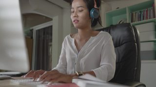 亚洲女人她在家工作她感到轻松成功视频素材模板下载