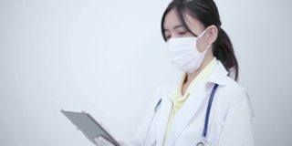 白袍女医生用平板电脑搜索一些疾病信息或阅读健康检查报告。