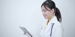 白袍女医生用平板电脑搜索一些疾病信息或阅读健康检查报告。