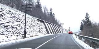 冬季汽车旅行概念骑在下雪的道路上