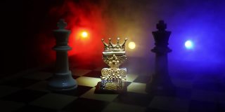 棋盘上漂亮的皇后/国王王冠。棋牌游戏的经营理念和竞争理念以及战略理念。象棋人物在烟雾缭绕的黑暗背景上。有选择性的重点