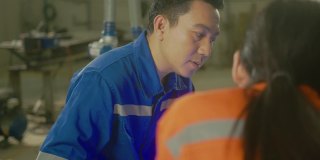 工程师合作两名亚洲男女技术员维护检查继电器机器人系统与平板电脑控制质量操作过程工作重工业4.0制造工厂