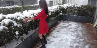 穿着红色衣服的年轻女子在雪地里玩耍
