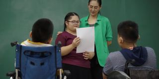 亚洲自闭症女孩在课堂上做活动和你的学校朋友练习你的口语技巧。教师引导自闭症患者发展大脑的表达。教育的概念
