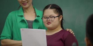 亚洲自闭症女孩在课堂上做活动和你的学校朋友练习你的口语技巧。教师引导自闭症患者发展大脑的表达。教育的概念