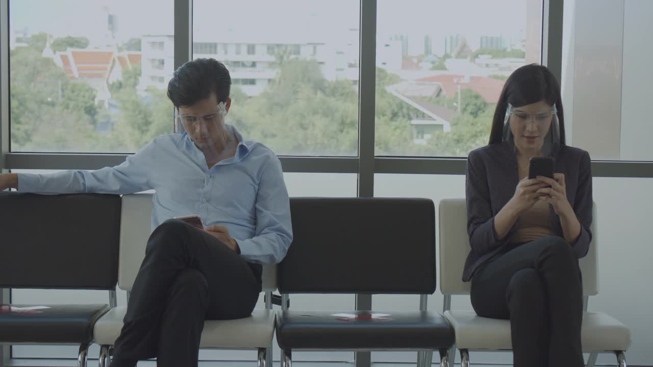 4K, COVID-19影响，两位亚洲同事用智能手机与朋友交流。