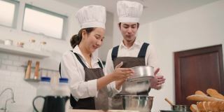 两个年轻的亚洲人在厨房一起做饭