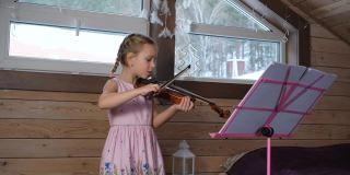 小女孩在家里拉小提琴和锻炼身体