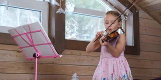 可爱的小小提琴家在阁楼练习