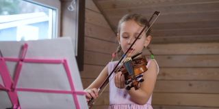 小女孩在家拉小提琴，唱歌