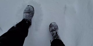两个人在下雪的路上走着。两个人的腿。在冬天走在路上