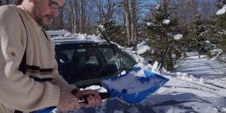 一个阳光明媚的冬日，一名50岁的白人男子正在用铲子清理他停在车道上的车。