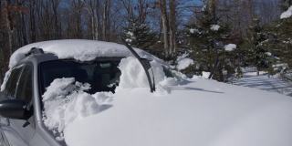 雪后停在车道上的一辆被雪覆盖的汽车。