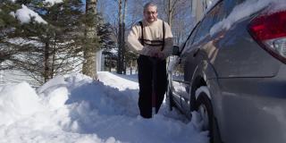 一个阳光明媚的冬日，一名50岁的白人男子正在用铲子清理他停在车道上的车，他的车被大雪覆盖。