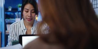 亚洲的商务人士使用笔记本电脑演示和交流会议头脑风暴关于新项目同事的工作计划成功策略在晚上现代家庭办公室。