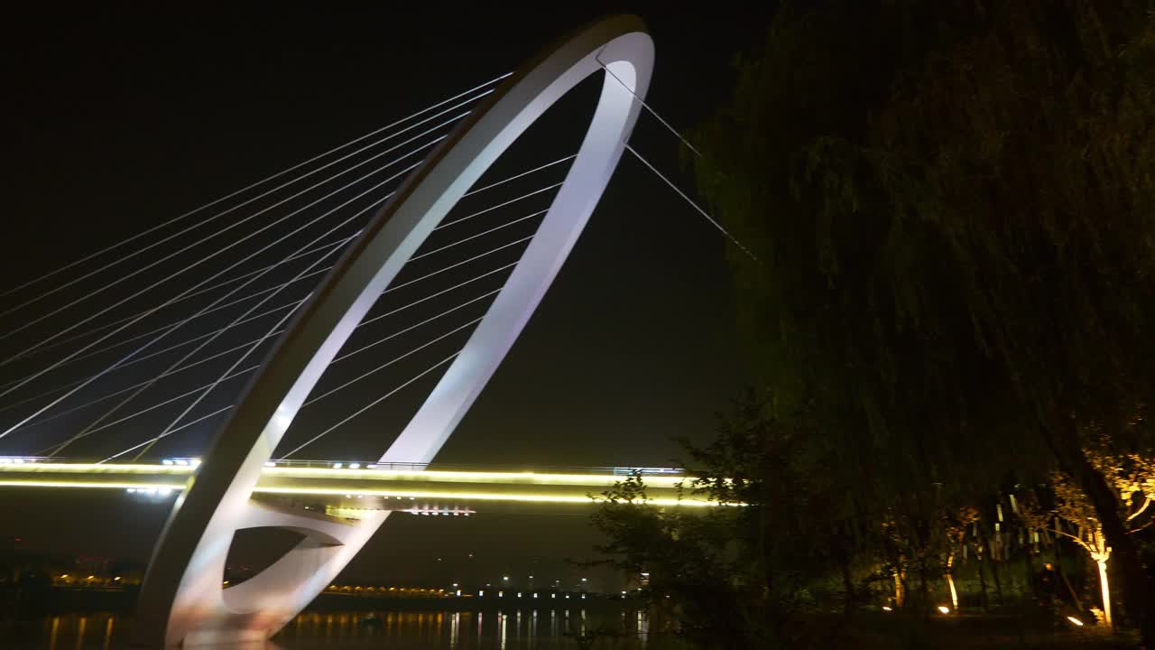 夜光时分，照亮了南京市内著名的现代化人行天桥，江滨公园全景4k中国