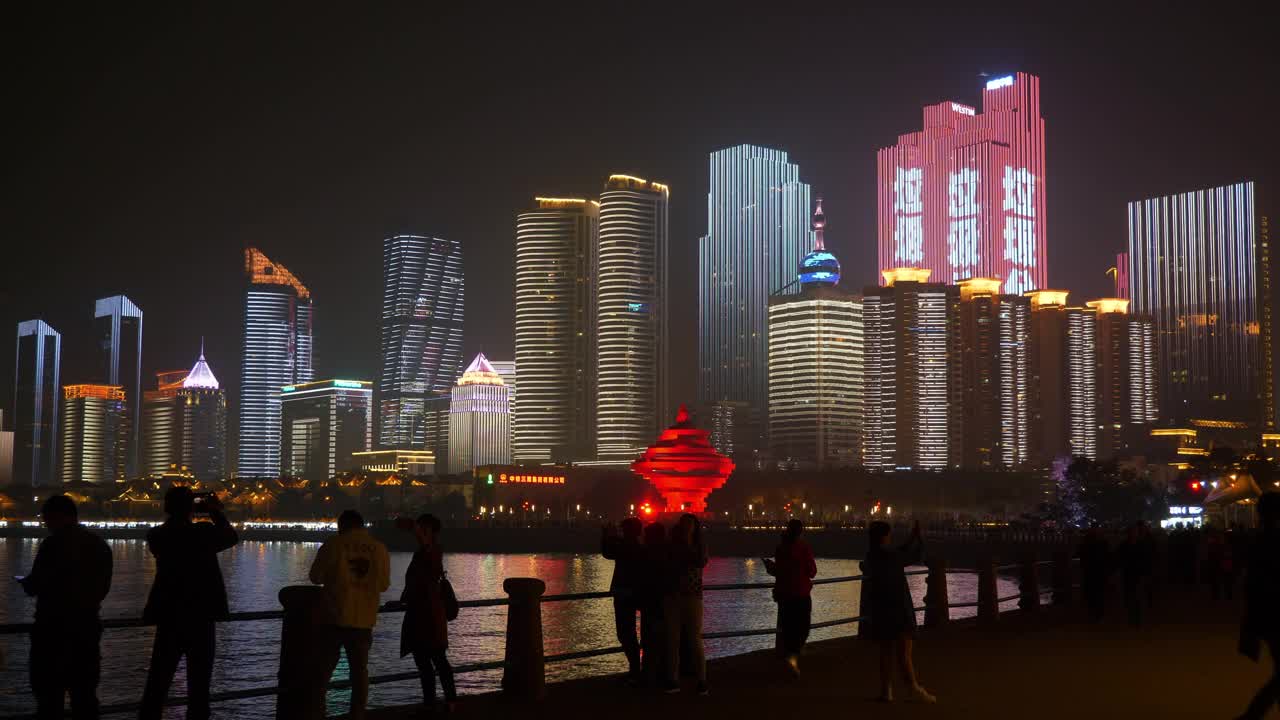 夜间照明著名的青岛市区展示拥挤的步行街全景4k中国