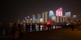夜间灯光下，著名的青岛城市展示拥挤的步行街全景4k中国
