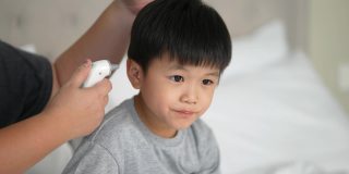 亚洲孩子感到恶心的温度计和母亲。照顾和生病的概念