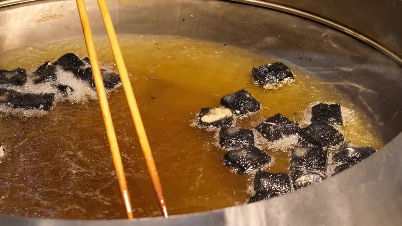 把臭豆腐放在锅里用油炸，这是中国的传统小吃