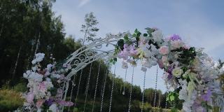 美丽的婚礼拱门上装饰着鲜花和其他装饰品。一阵微风吹来。四周都是美丽的大自然