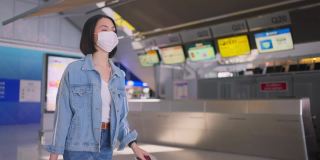 新冠肺炎疫情期间，佩戴口罩的女乘客在机场航站楼走向登机口，以防止感染新冠肺炎。飞机运输的新常态生活理念