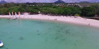 在印度洋和毛里求斯岛的阿尔比恩海滩。背景中的海岸线和人们在玩耍和日光浴