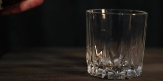 将威士忌倒入玻璃杯的超级慢动作镜头