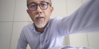 亚洲华人资深男教授家教老师给他的成年学生使用笔记本电脑在家里工作