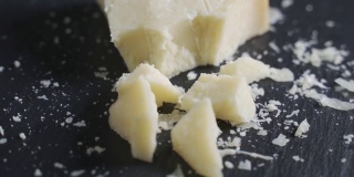 新鲜的三角形法国美味帕尔玛干酪块放在木板上