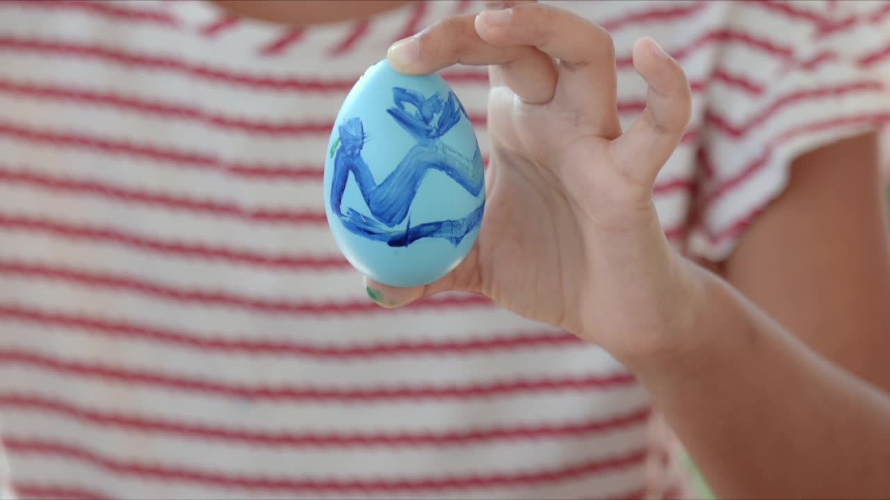 亚洲的小女孩手里正拿着五颜六色的复活节彩蛋。