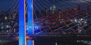 在科修斯科大桥上，曼哈顿中城的夜景。航拍视频与平移和上升的摄像机运动。