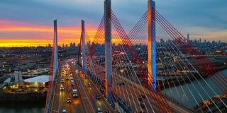 黄昏时分，灯火通明的Kosciuszko桥鸟瞰图，威廉斯堡工业区上方曼哈顿和布鲁克林的远景。用静态摄像机拍摄无人机视频。