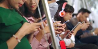 年轻人在公共地铁上使用手机