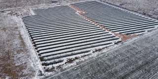冬季雪地使用光伏元件生产可再生能源的太阳能发电站鸟瞰图