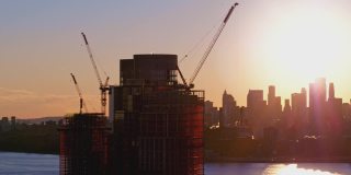 布鲁克林滨水区新建住宅楼，日落时分，可以看到曼哈顿下城的天际线和自由塔的美景。航拍视频与平移摄像机运动。