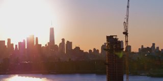 布鲁克林滨水区新建住宅楼，日落时分，可以看到曼哈顿下城的天际线和自由塔的美景。航拍视频与平移摄像机运动。