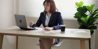 商业女性视频会议使用笔记本电脑和平板电脑在线会议。在家工作