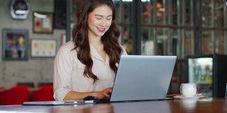 幸福迷人的亚洲女性工作与笔记本电脑思考，以获得想法和需求在现代办公室或联合办公空间创业，创业概念