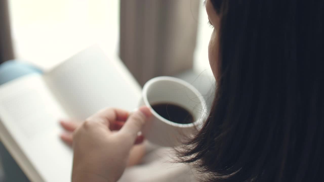 女人在家里放松的时候看书喝咖啡