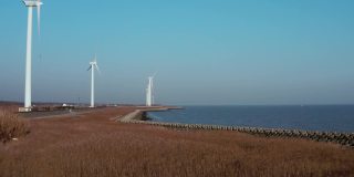 中国上海海边白色风力涡轮机和黄色芦苇的航拍照片