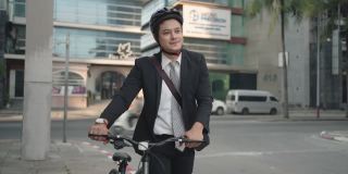 亚洲商人在早上推着他的自行车从家里准备骑他的自行车上班。生态交通运输。