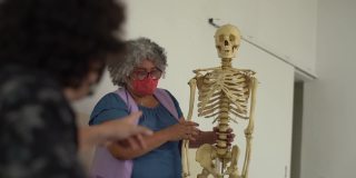 老师在课堂上教人体解剖学，戴着骷髅面具